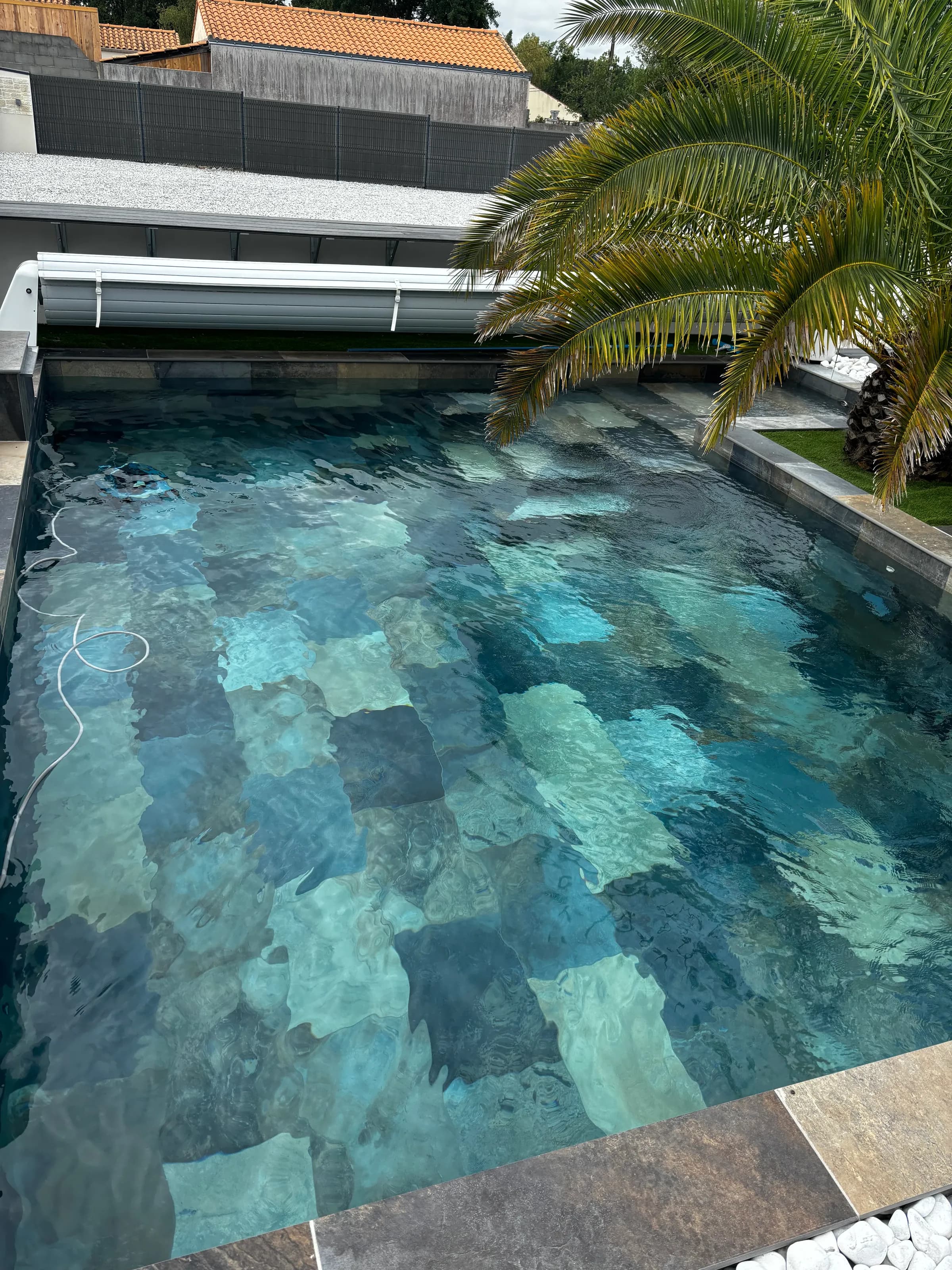 Après rattrapage : la même piscine à l'eau claire et turquoise, fond en pierre à nouveau visible.