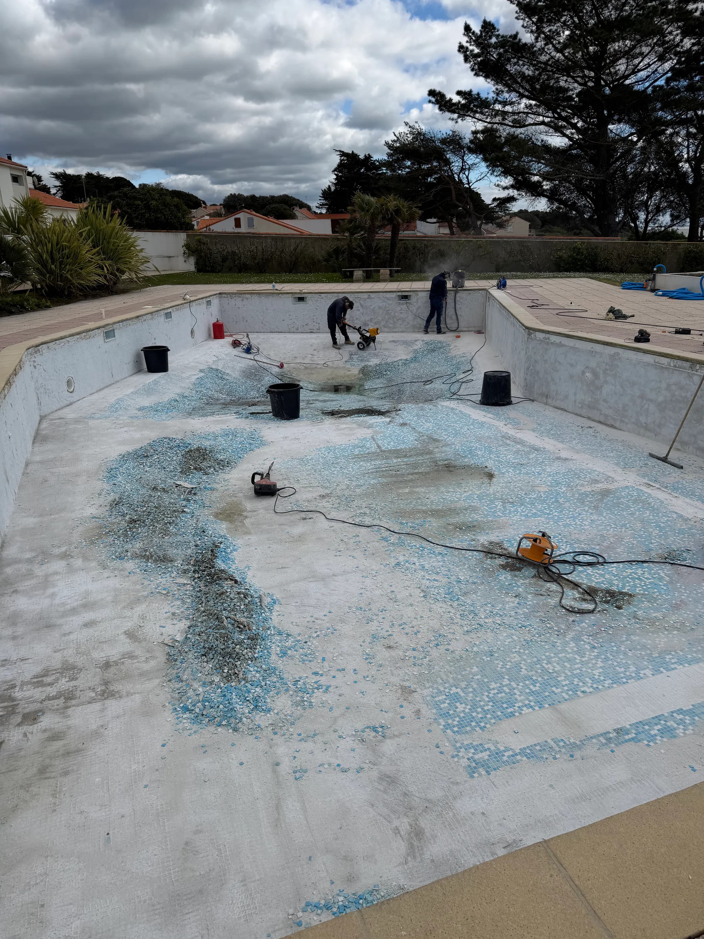 Bassin collectif de Pornic vidé, dépose de l'ancienne mosaïque bleue en cours de chantier.