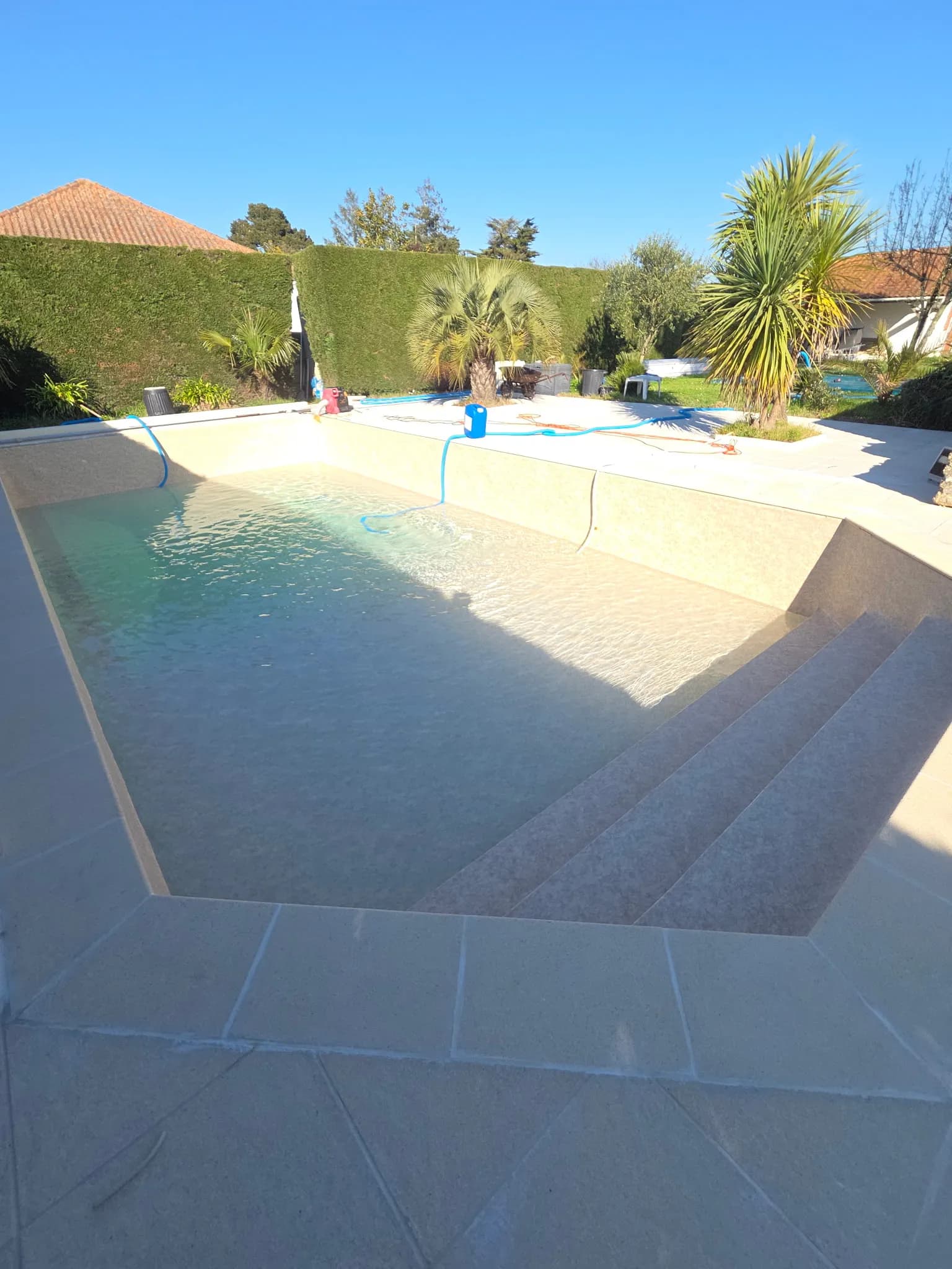 Après rénovation : piscine 12x5 m en liner 3D sable avec marche Safety Ledge et pointe en diamant.